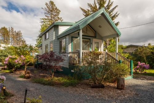 a small green and white house with a porch at Sheltered Nook On Tillamook Bay in Bay City