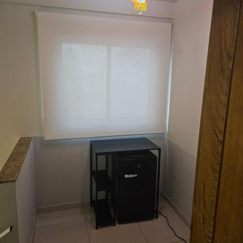 a small black table in a room with a window at Casa de Praia em Jacaraipe soneto do Mar in Serra