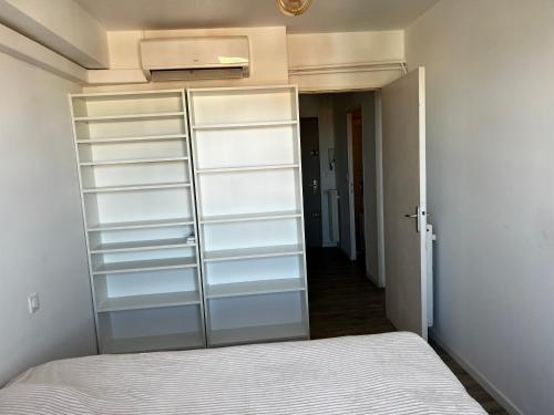 - une chambre avec placard et étagères blanches dans l'établissement Appartement vue sur mer et montagne, à Perpignan