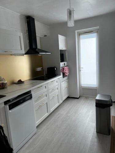 La cuisine est équipée de placards blancs et d'un four avec plaques de cuisson blanches. dans l'établissement Appartement vue sur mer et montagne, à Perpignan
