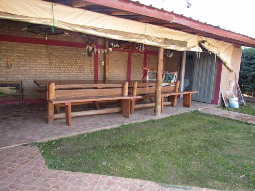 a wooden bench sitting outside of a house at CABAÑAS SANTA RITA - Tanti, Córdoba in Tanti