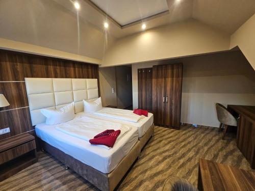 a bedroom with a large bed with red pillows on it at Hotel City Faber in Worms