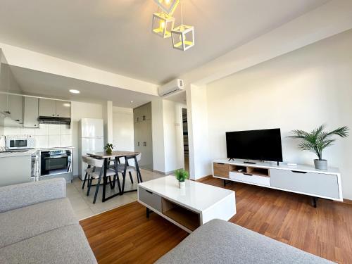 a living room with a couch and a flat screen tv at Sherpa Apartments in Ayia Napa
