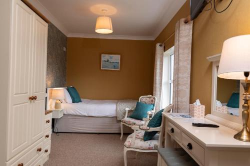 a bedroom with a bed and a desk and a chair at Murphys Farmhouse B&B in Castlemaine