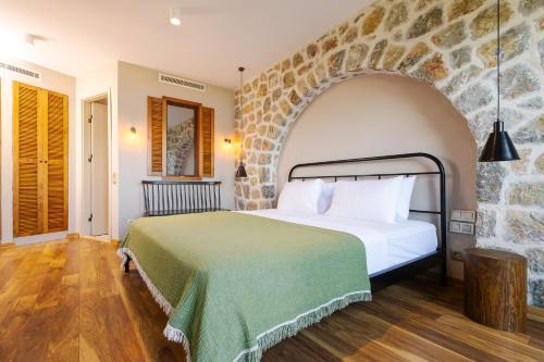 a bedroom with a large bed with a stone wall at Boho Garden Selimiye in Selimiye