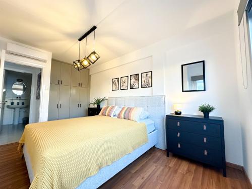 a bedroom with a yellow bed and a black dresser at Sherpa Apartments in Ayia Napa