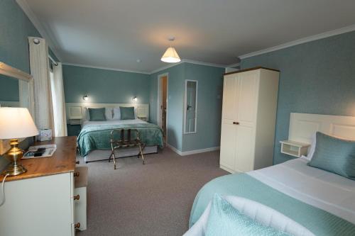 a bedroom with two beds and a desk with a lamp at Murphys Farmhouse B&B in Castlemaine