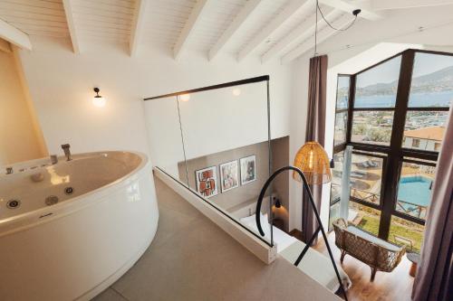 a large bathroom with a tub and a large window at Boho Garden Selimiye in Selimiye