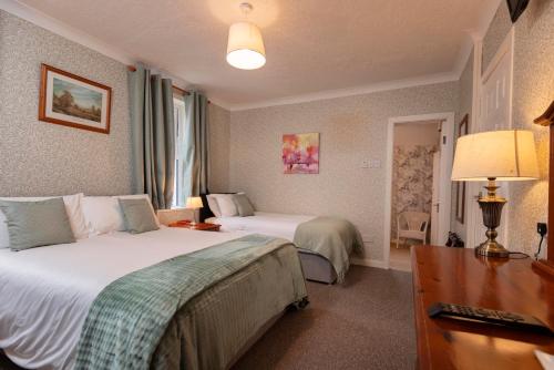 a hotel room with two beds and a desk at Murphys Farmhouse B&B in Castlemaine