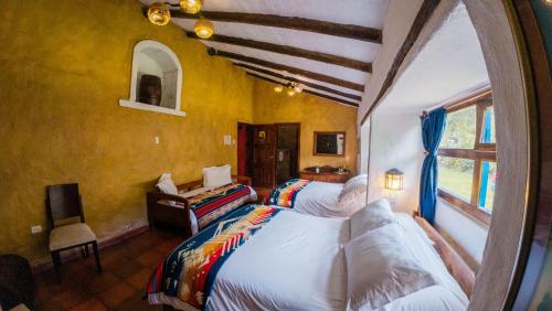 a bedroom with two beds and a window at Hacienda San Francisco in Tumbabiro
