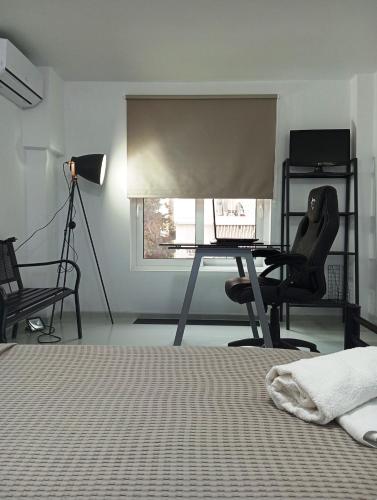 a bedroom with a desk with a laptop and a chair at Rethymno Central Studio in Áyios Andónios