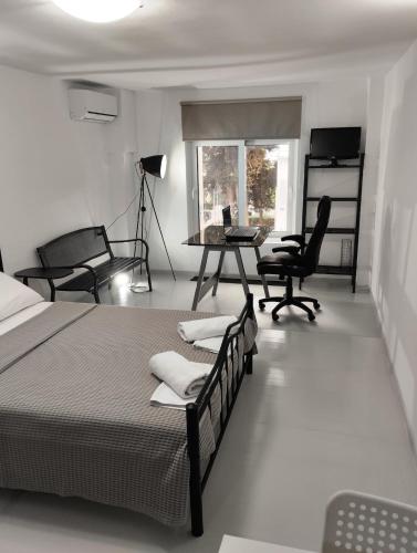 a bedroom with a bed and a desk and chairs at Rethymno Central Studio in Áyios Andónios