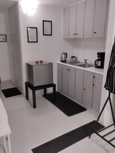 a kitchen with white cabinets and a table in it at Rethymno Central Studio in Áyios Andónios