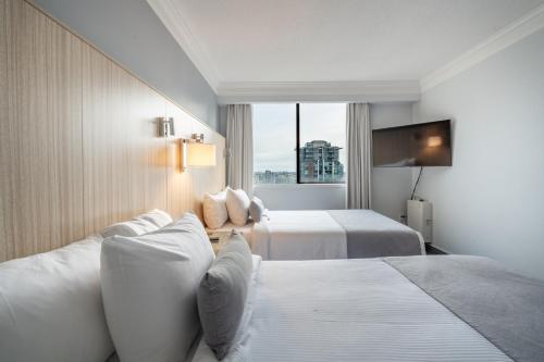 a hotel room with two beds and a window at Century Plaza Hotel in Vancouver