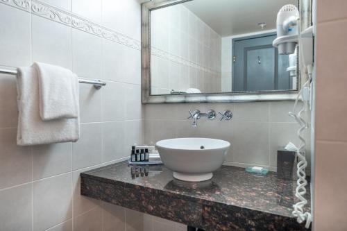 a bathroom with a sink and a mirror at Century Plaza Hotel in Vancouver