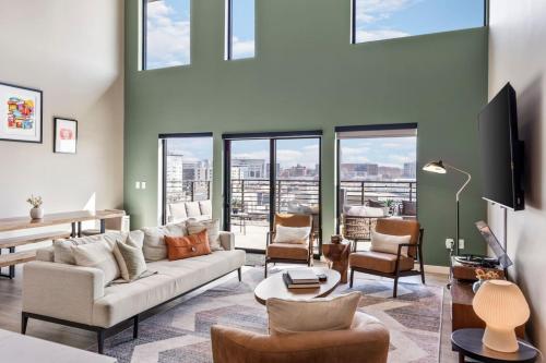 a living room with a couch and chairs and windows at Penthouse Luxury with Pool Patio and City View plus Walk to Broadway in Nashville