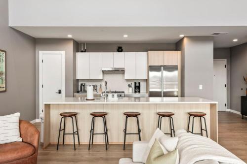 a kitchen with a counter and bar with stools at Penthouse Luxury with Pool Patio and City View plus Walk to Broadway in Nashville