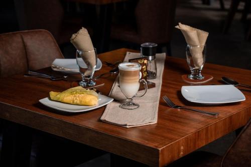 a wooden table with a plate of food and glasses at Hacienda San Francisco in Tumbabiro