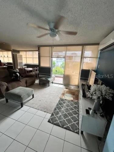 a living room with a couch and a ceiling fan at Private King Room with bath in Shared Apartment in San Juan