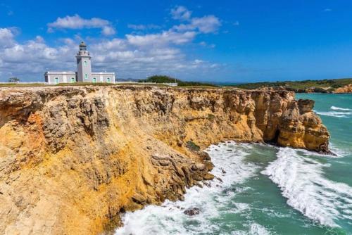 a lighthouse on top of a cliff next to the ocean at Private King Room with bath in Shared Apartment in San Juan