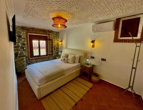 a bedroom with a bed and a television in it at Riad abi khancha in Chefchaouen