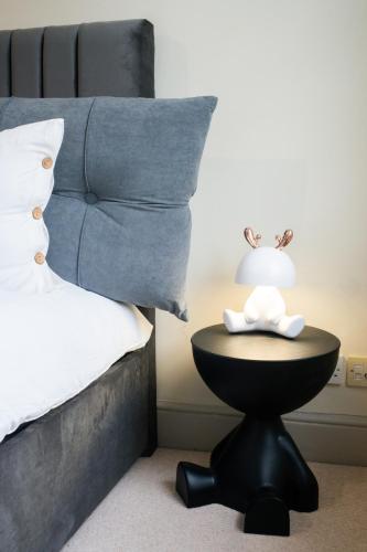 a bedroom with a bed and a table with a lamp at 3-Bed gem with Bath Abbey views in Bath