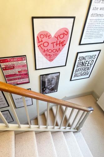 a wall of posters and pictures on a stair case at 3-Bed gem with Bath Abbey views in Bath