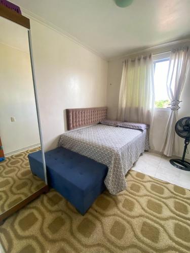 a bedroom with a bed and a blue ottoman at COP30 aluguel in Marituba
