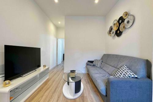 un salon avec un canapé et une télévision à écran plat dans l'établissement neuf climatisé et proche métro, à Villeurbanne