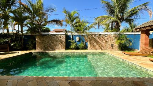 a swimming pool in front of a house at Casarão Dos Santos - Guest House in Peruíbe