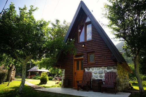 a log cabin with two chairs in front of it at Ethno Village Štitarica in Mojkovac