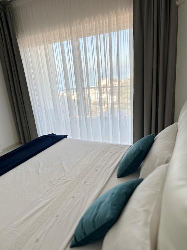 un letto con cuscini blu di fronte a una finestra di Residence Dominic a Peschici