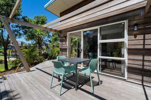a patio with a table and chairs on a deck at Tasman Holiday Parks - Papamoa Beach in Papamoa