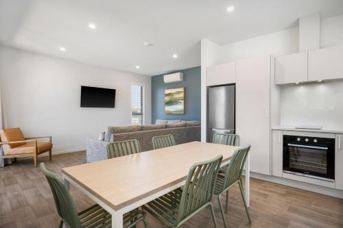 a kitchen and living room with a table and chairs at Tasman Holiday Parks - Papamoa Beach in Papamoa