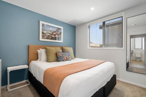 a bedroom with a large bed with blue walls at Tasman Holiday Parks - Papamoa Beach in Papamoa