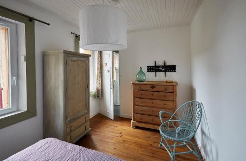 a bedroom with a bed and a dresser and a chair at Gite de l'abreuvoir N 2 pour 8 personnes in Cuverville-sur-Yères