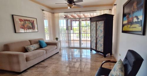 Una sala de estar con un sofá y una ventana grande. en 9th hole Villa, en Los Conucos
