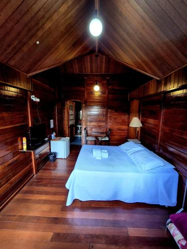 a bedroom with a large bed in a wooden room at Pássaro de Fogo in Santo Antônio do Pinhal