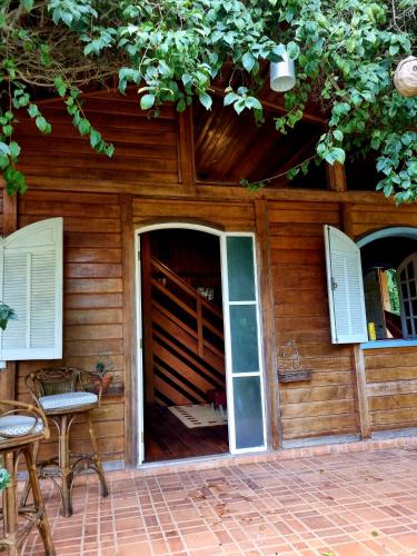 a wooden house with a door and two windows at Pássaro de Fogo in Santo Antônio do Pinhal