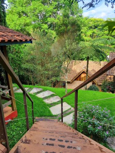 a wooden walkway leading to a yard with a house at Pássaro de Fogo in Santo Antônio do Pinhal