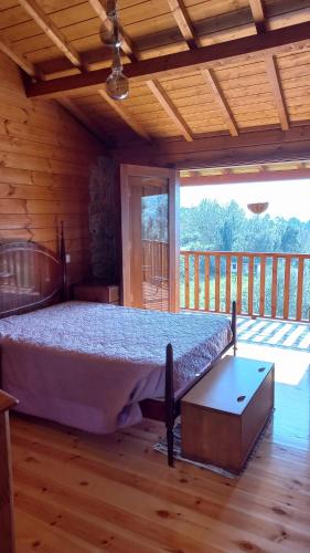 a bedroom with a bed in a log cabin at Casa das Fragas in Celorico de Basto
