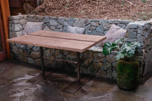 a wooden table sitting in front of a stone wall at Magical Yurt in the woods - 2 miles from town in Nevada City