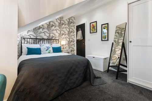 a bedroom with a large bed with blue pillows at 3a Roman View, beautifully appointed apartment in Roundhay, sleeps up to 6, bedrooms with en suite bathrooms, EV charging in Moortown