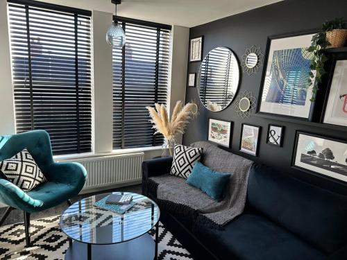a living room with a blue couch and a glass table at 3a Roman View, beautifully appointed apartment in Roundhay, sleeps up to 6, bedrooms with en suite bathrooms, EV charging in Moortown