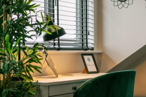 a room with a desk with a window and plants at 3a Roman View, beautifully appointed apartment in Roundhay, sleeps up to 6, bedrooms with en suite bathrooms, EV charging in Moortown