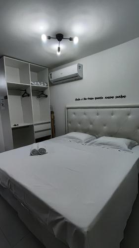 a bedroom with a large white bed with glasses on it at Flat Studio in João Pessoa
