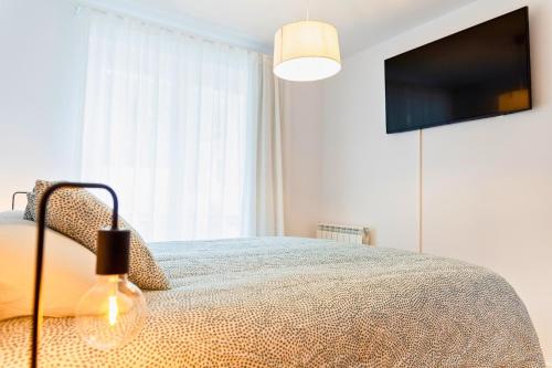a bedroom with a bed and a flat screen tv at Refugio de Montaña, Terraza con Vistas y Parking I AndBnB in Arinsal