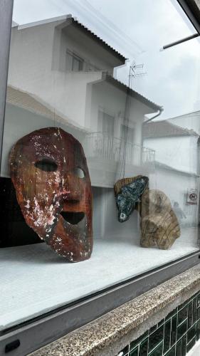a display window with a mask and other artifacts at Feel at Home Guest House in Ovar