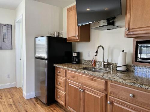 a kitchen with a black refrigerator and a sink at Beach Breeze Inn in Falmouth