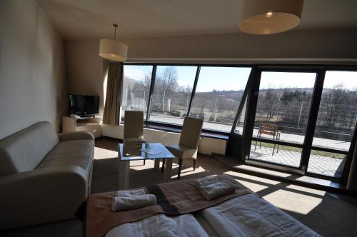 a living room with a couch and a large window at Szklane Domy in Zakopane